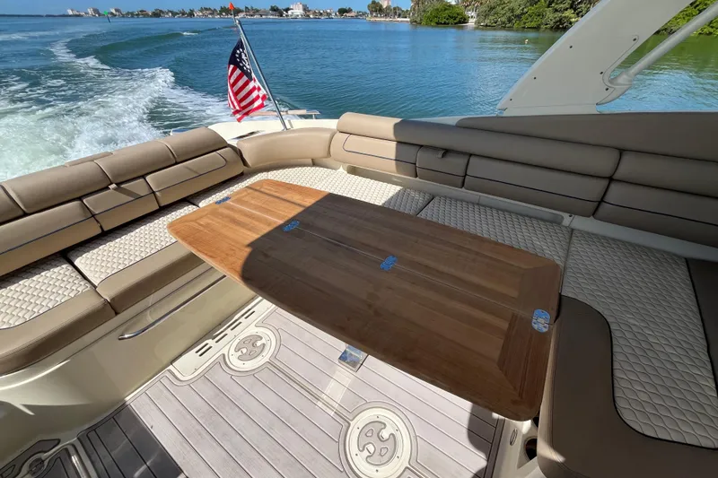 Slide: The Image of 2022 Chris-Craft Launch 35 GT I/O interior with seating and wooden table on water. - 14