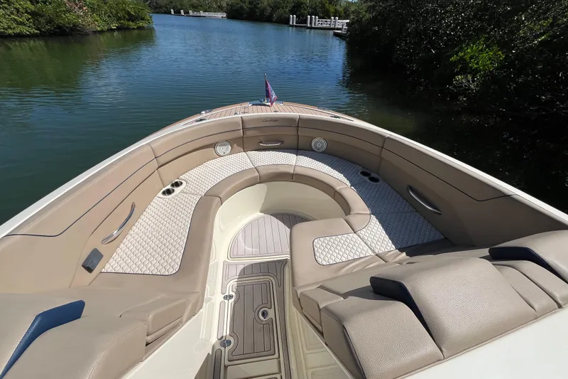 Slide: The Image of 2022 Chris-Craft Launch 35 GT I/O boat interior with luxurious seating on calm water. - 24