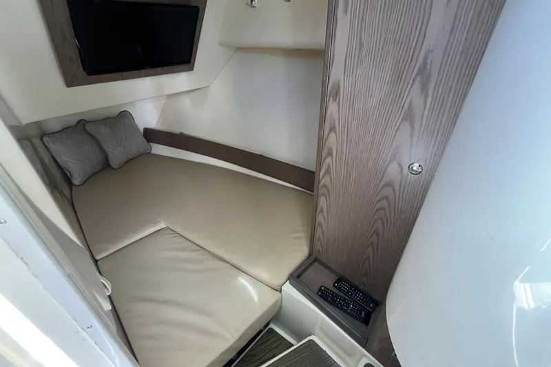 Slide: The Image of 2022 Chris-Craft Launch 35 GT I/O cabin interior with beige seating and TV. - 27
