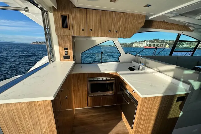 Slide: The Image of Luxurious 2024 Cruisers Yachts 50 Cantius kitchen with modern wood cabinetry and ocean view. - 14