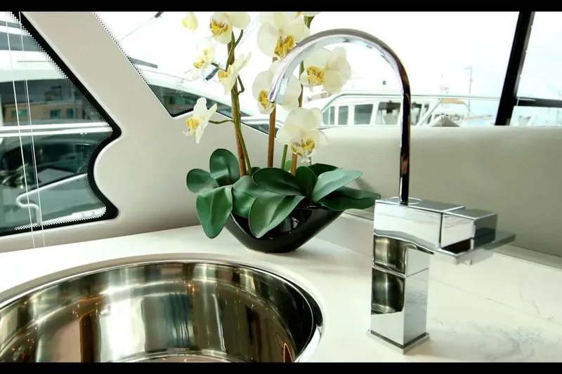 Slide: The Image of Luxurious interior of 2024 Cruisers Yachts 50 Cantius with sleek sink and elegant orchid arrangement. - 15