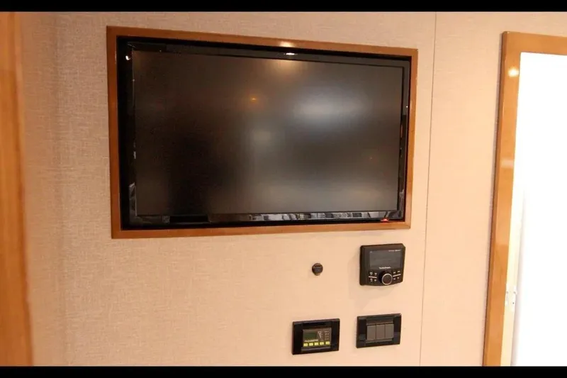 Slide: The Image of 2024 Cruisers Yachts 50 Cantius interior with wall-mounted TV and control panels. - 36