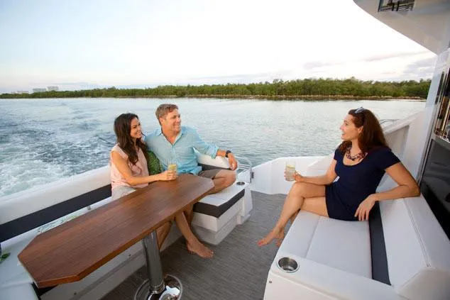 Slide: The Image of Three people relaxing on a 2024 Cruisers Yachts 50 Cantius, enjoying a scenic boat ride. - 9