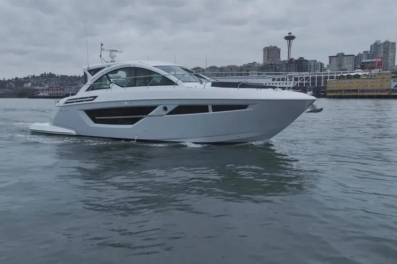 Slide: The Image of 2024 Cruisers Yachts 50 Cantius on water with city skyline background. - 1