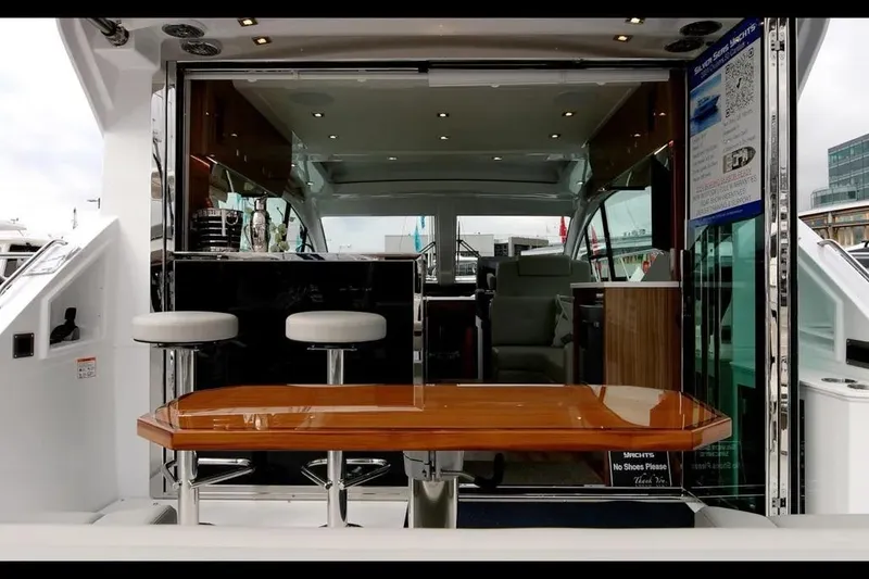 Slide: The Image of 2024 Cruisers Yachts 50 Cantius interior with bar stools and wooden table. - 11