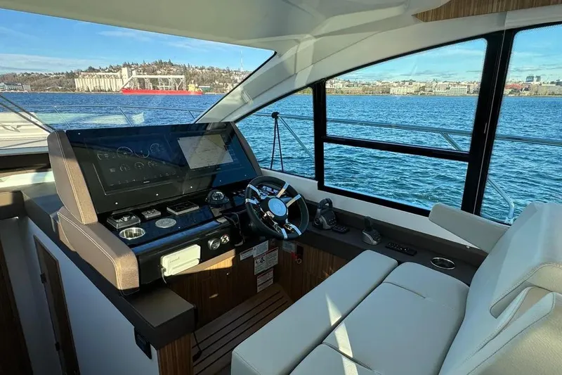Slide: The Image of 2024 Cruisers Yachts 50 Cantius helm with modern controls and scenic water view. - 22