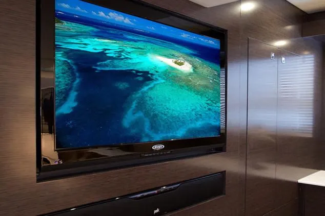 Slide: The Image of 2024 Cruisers Yachts 50 Cantius interior with wall-mounted TV displaying ocean scene. - 42