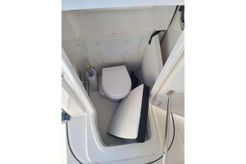 Slide: The Image of 2023 Robalo R270 Center Console boat interior with compact marine toilet. - 13