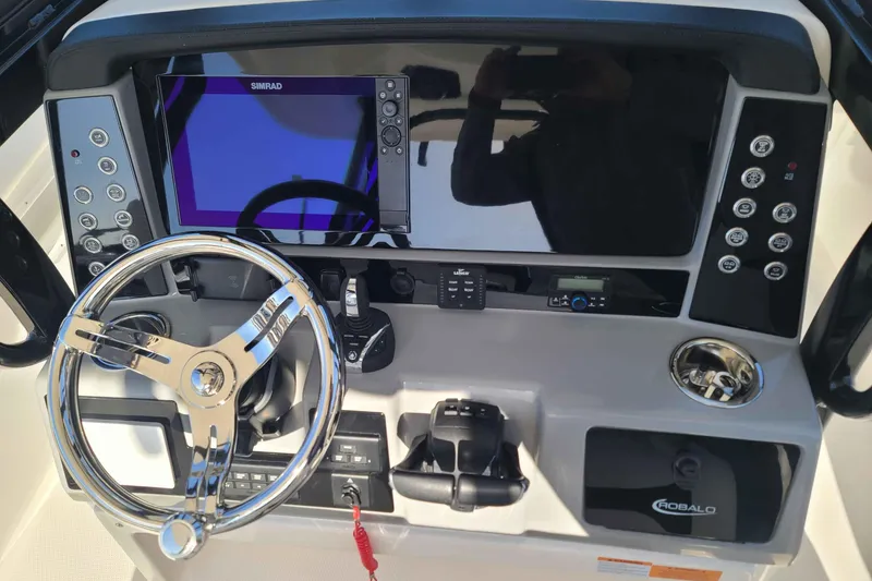 Slide: The Image of 2023 Robalo R270 Center Console dashboard with steering wheel and electronic controls. - 8