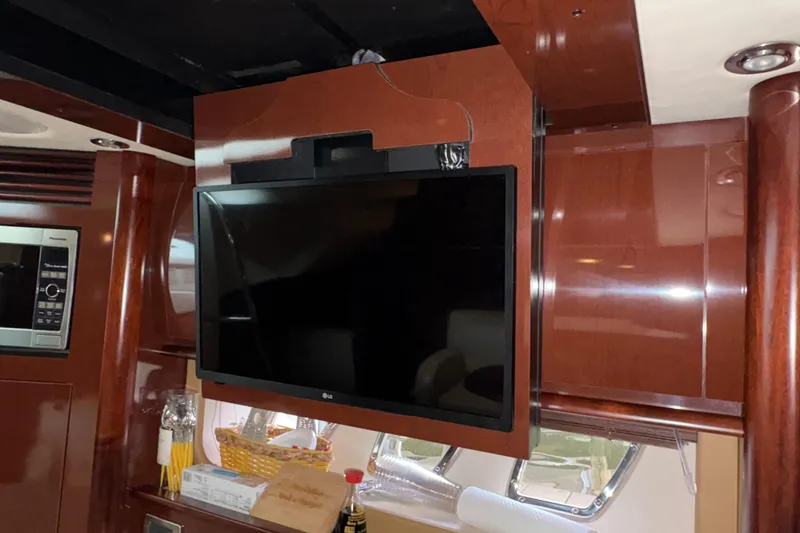 Slide: The Image of Interior of 2008 Sea Ray 40 Sundancer with mounted LG TV and wooden cabinetry. - 11