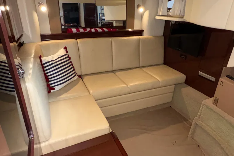 Slide: The Image of Interior of 2008 Sea Ray 40 Sundancer yacht with beige seating and striped pillow. - 17