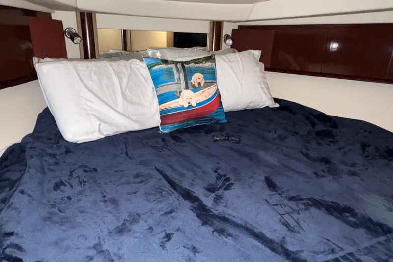 Slide: The Image of Cozy cabin bed in 2008 Sea Ray 40 Sundancer with decorative pillow and navy blanket. - 22