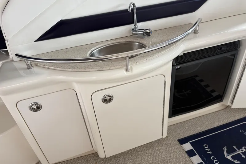 Slide: The Image of 2008 Sea Ray 40 Sundancer yacht kitchenette with sink, storage cabinets, and mini fridge. - 4