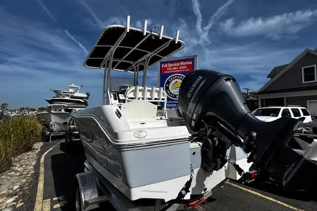 Slide: The Image of 2024 Robalo R180 Center Console boat with Yamaha engine, parked near waterfront buildings. - 1