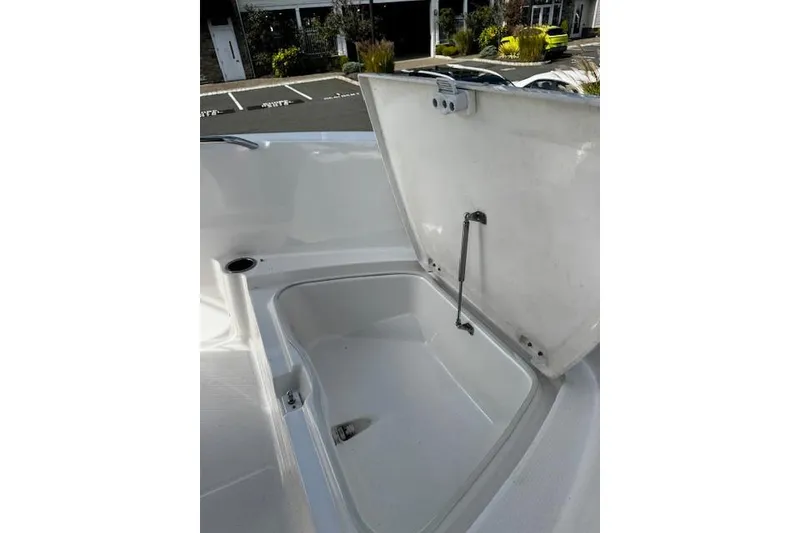 Slide: The Image of 2024 Robalo R180 Center Console boat interior storage compartment with portable toilet. - 13