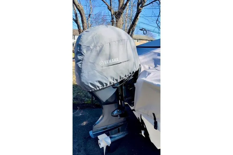 Slide: The Image of 2024 Robalo R180 Center Console with Yamaha engine cover, parked outdoors. - 19