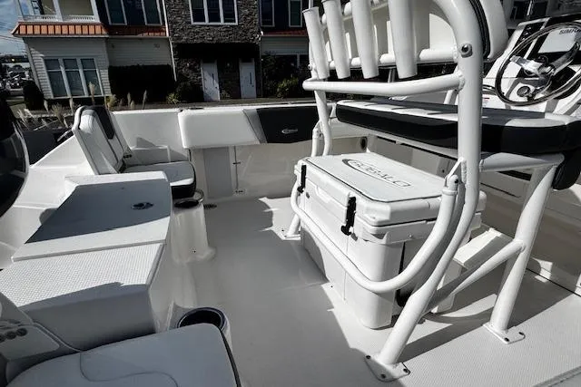 Slide: The Image of 2024 Robalo R180 Center Console boat on trailer, parked outdoors under blue sky. - 2