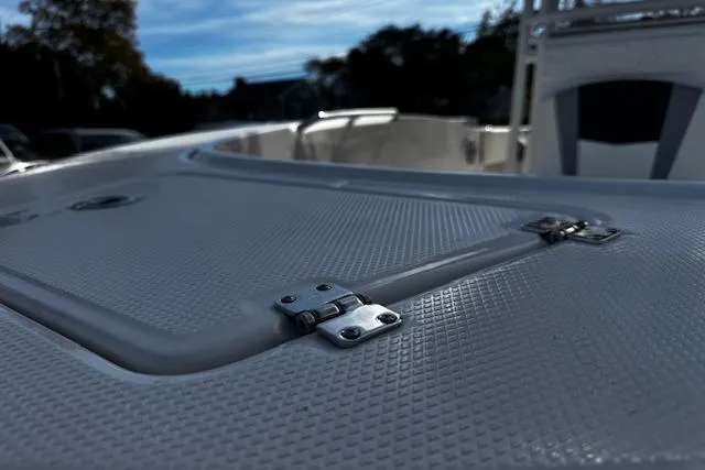 Slide: The Image of 2024 Robalo R180 Center Console boat interior with seating and storage, docked near buildings. - 9