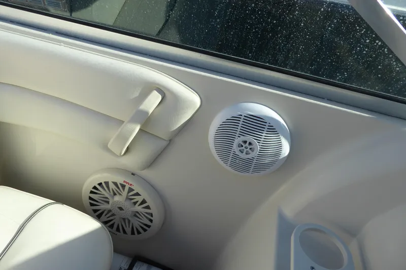 Slide: The Image of Interior of 2004 Sea Ray 225 Weekender boat with speakers and white seating. - 11