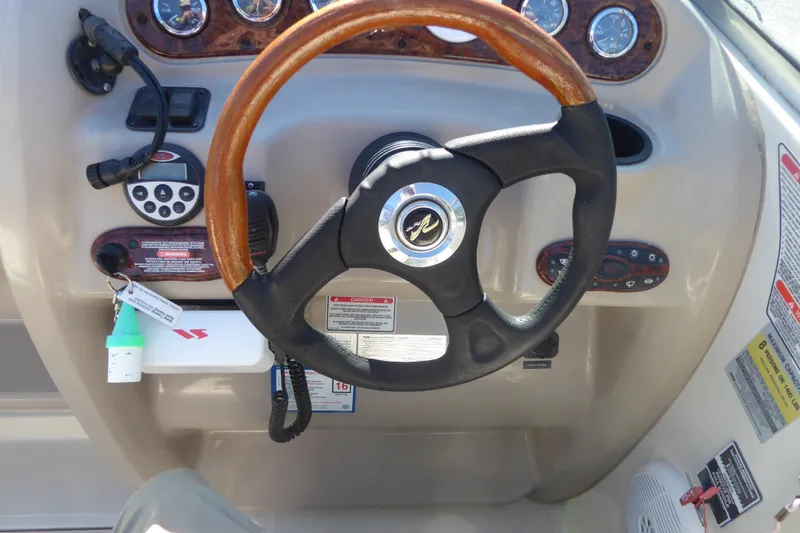 Slide: The Image of Steering wheel and dashboard of a 2004 Sea Ray 225 Weekender boat. - 16