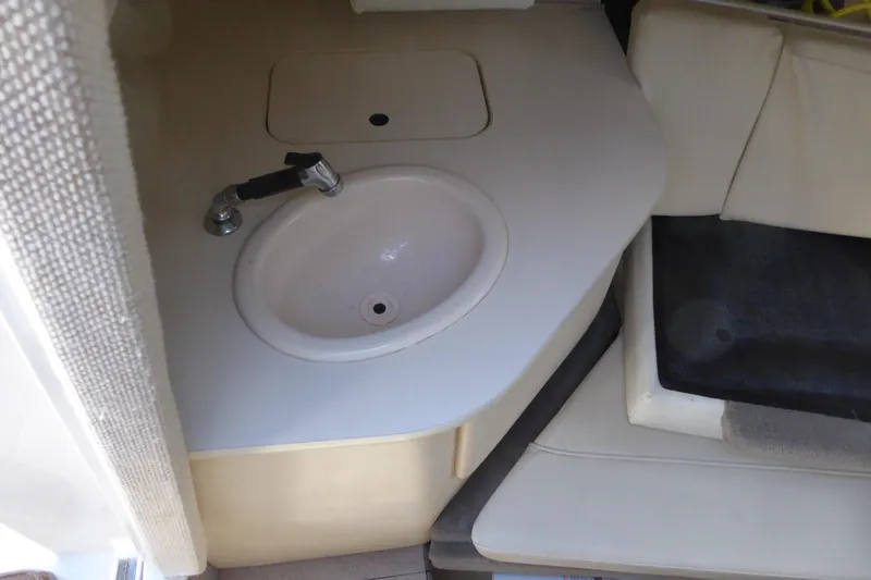 Slide: The Image of 2004 Sea Ray 225 Weekender interior with sink and seating area. - 26