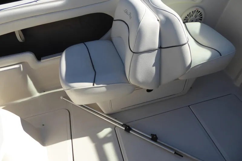 Slide: The Image of 2004 Sea Ray 225 Weekender boat interior with white seating and speaker. - 4