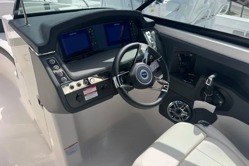 Slide: The Image of 2025 Chaparral 270 OSX boat dashboard with steering wheel and control panel. - 13