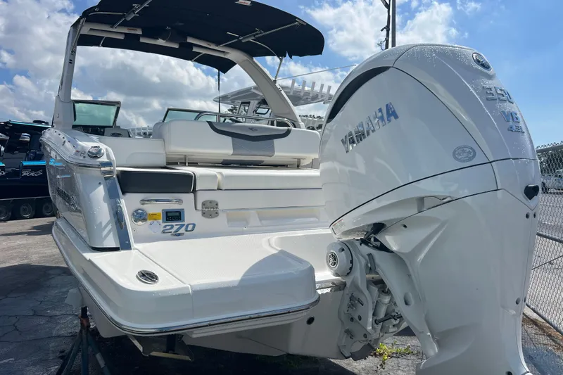 Slide: The Image of 2025 Chaparral 270 OSX boat with Yamaha engine, docked under a sunny sky. - 3