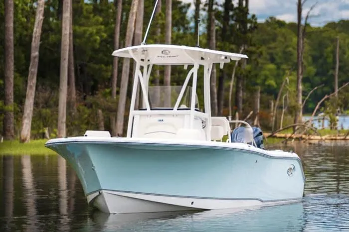 Slide: The Image of Manufacturer Provided Image: 2026 Sea Hunt Ultra 229 boat on a serene lake with forest backdrop. - 1