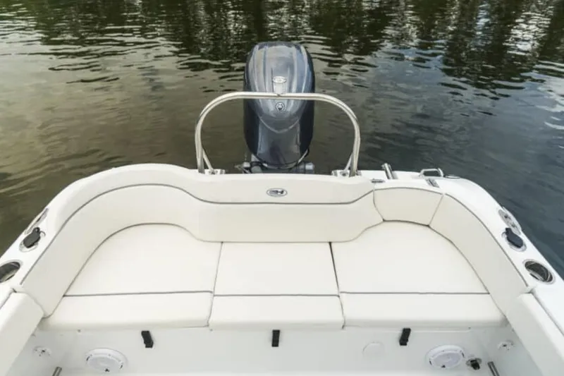 Slide: The Image of Manufacturer Provided Image: 2026 Sea Hunt Ultra 229 boat with cushioned seating and outboard motor on calm water. - 6