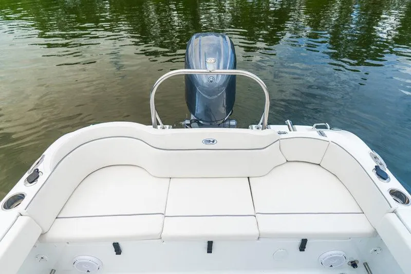 Slide: The Image of 2026 Sea Hunt Ultra 229 boat with white seating and outboard motor on calm water. - 9