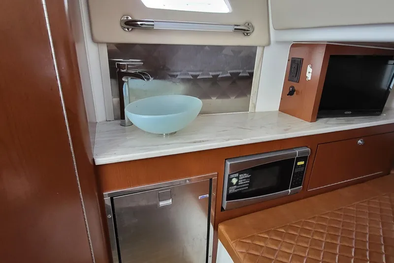 Slide: The Image of 2018 Edgewater 370CC interior with sink, microwave, and seating area. - 12