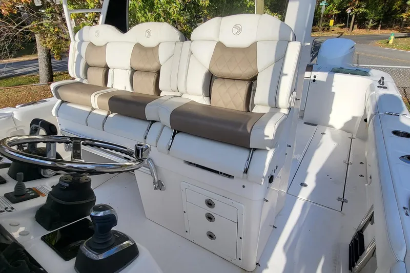 Slide: The Image of 2018 Edgewater 370CC boat interior with dual cushioned seats and steering wheel. - 18