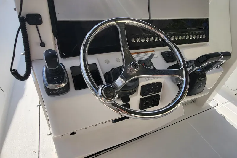 Slide: The Image of Steering console of 2018 Edgewater 370CC boat with controls and chrome wheel. - 19