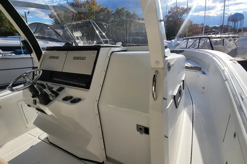 Slide: The Image of 2018 Edgewater 370CC boat cockpit with Simrad navigation system and steering wheel. - 6