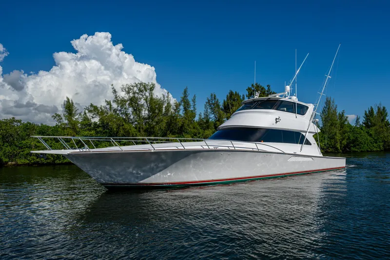 Slide: The Image of 2008 Viking 74 Enclosed Bridge yacht on calm water, clear sky background. - 10