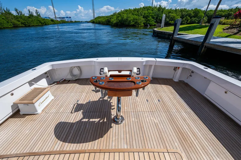 Slide: The Image of 2008 Viking 74 Enclosed Bridge yacht deck with fishing station, docked by a scenic waterway. - 12