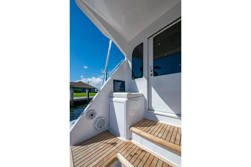 Slide: The Image of 2008 Viking 74 Enclosed Bridge yacht with teak steps and sleek white exterior. - 15