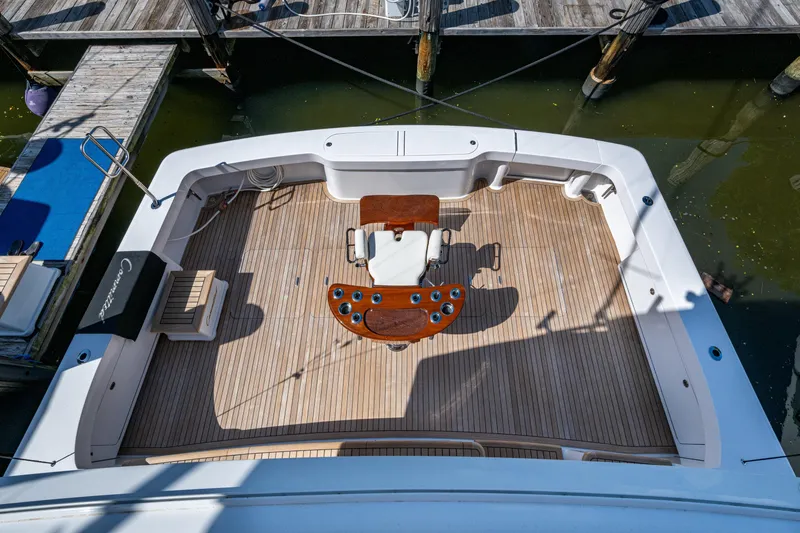 Slide: The Image of 2008 Viking 74 Enclosed Bridge yacht deck with wooden flooring and fishing chair. - 17