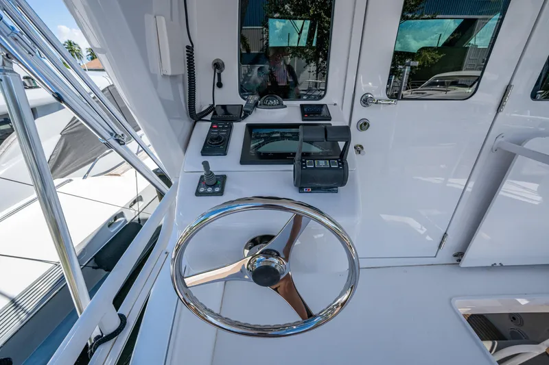 Slide: The Image of 2008 Viking 74 Enclosed Bridge yacht helm with steering wheel and navigation controls. - 22