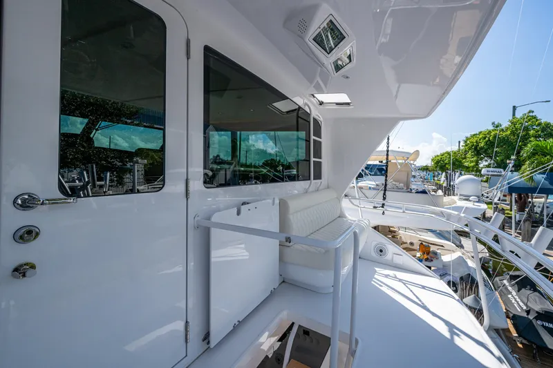 Slide: The Image of 2008 Viking 74 Enclosed Bridge yacht with sleek white exterior and spacious seating area. - 23