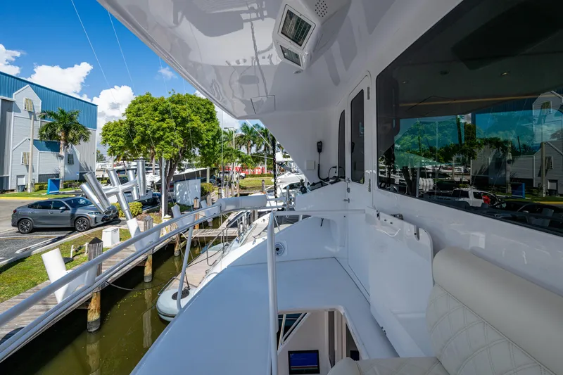 Slide: The Image of 2008 Viking 74 Enclosed Bridge yacht docked at marina, featuring sleek white design. - 25