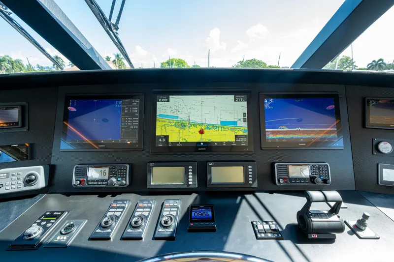 Slide: The Image of Control panel of 2008 Viking 74 Enclosed Bridge yacht with navigation screens and controls. - 34