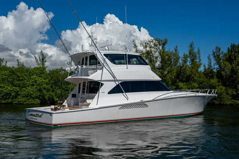 Slide: The Image of 2008 Viking 74 Enclosed Bridge yacht on calm water, surrounded by lush greenery. - 5