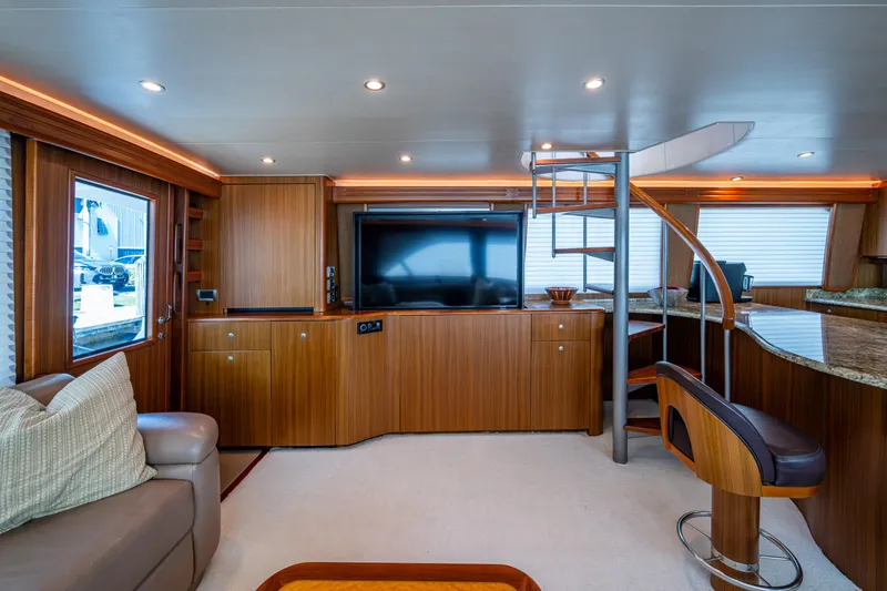 Slide: The Image of Luxurious interior of 2008 Viking 74 Enclosed Bridge yacht with modern wood finishes and spiral staircase. - 51