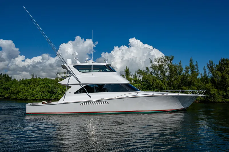 Slide: The Image of 2008 Viking 74 Enclosed Bridge yacht cruising on a sunny day with lush greenery. - 6