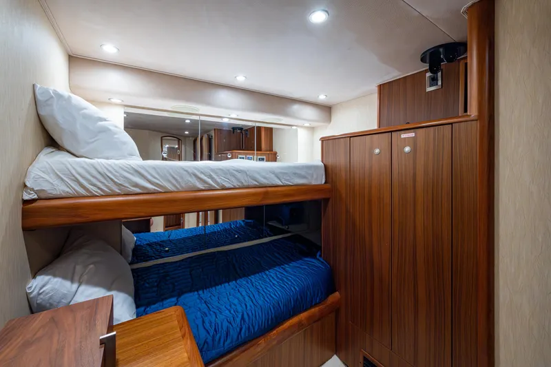 Slide: The Image of Interior of 2008 Viking 74 Enclosed Bridge yacht with cozy bunk beds and wooden cabinetry. - 61