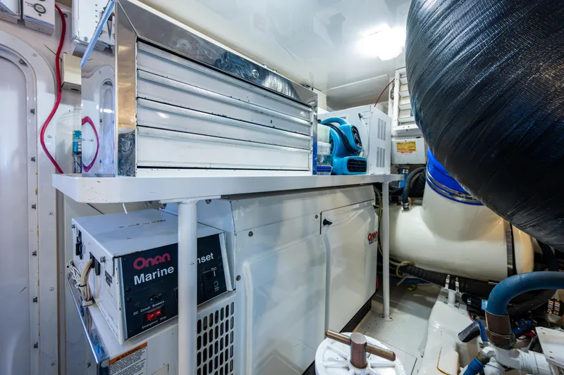 Slide: The Image of Engine room of 2008 Viking 74 Enclosed Bridge with Onan marine generator and tool storage. - 71