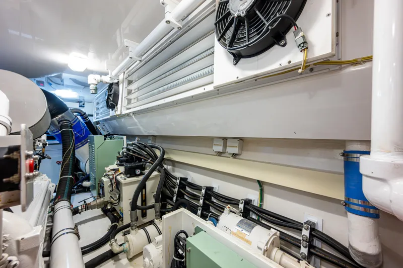 Slide: The Image of Engine room of 2008 Viking 74 Enclosed Bridge yacht, showcasing mechanical components and wiring. - 74