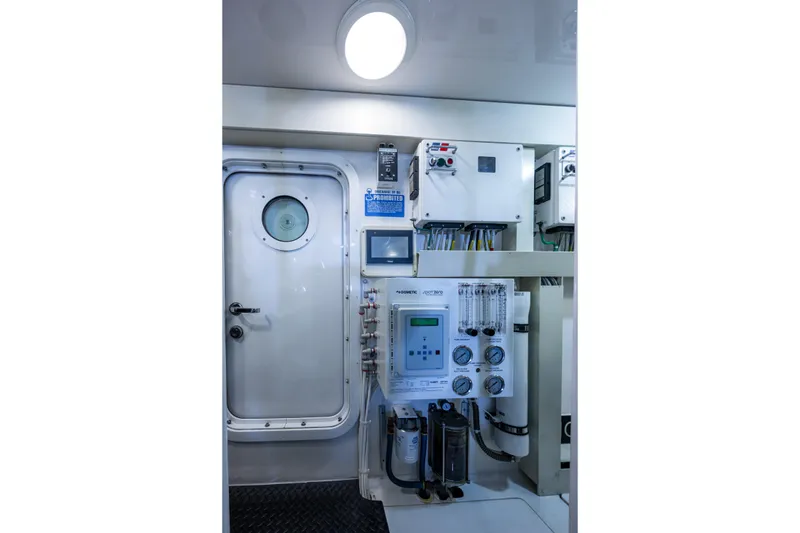 Slide: The Image of Control room of 2008 Viking 74 Enclosed Bridge yacht, featuring advanced equipment and secure door. - 77